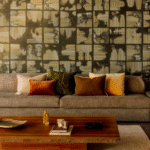 Moderne zithoek met Elitis Edmond CO 262 kussens op een grijze bank en een kunstzinnige wand met grafisch patroon.