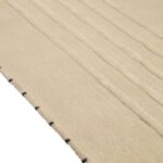 Detail van het Elitis Ernest TA 132 04 02 vloerkleed met een geweven structuur en subtiele reliëflijnen in beige tint.