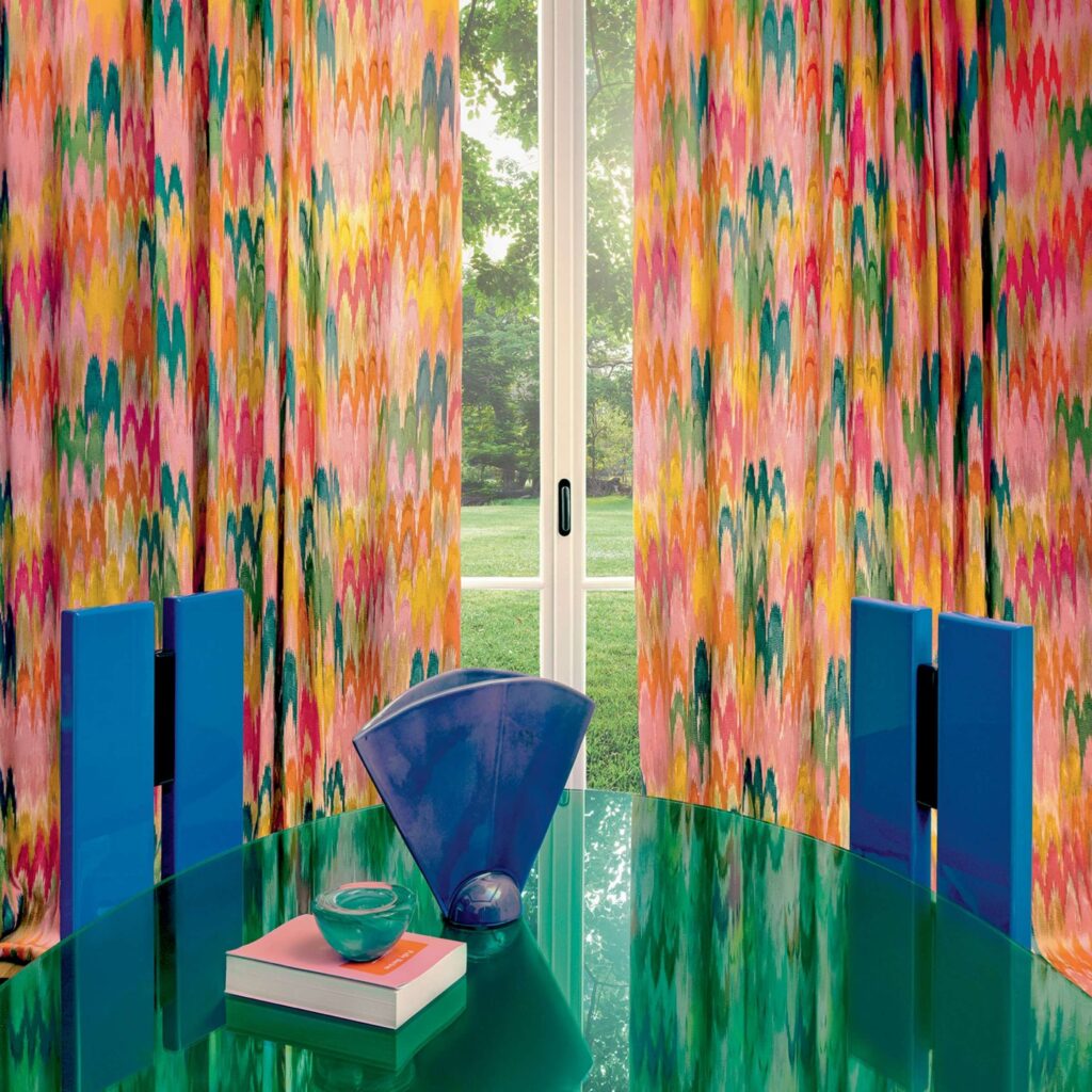 Kleurrijke Elitis Excentric Groovy gordijnen met een vrolijk patroon in een modern interieur met glanzende meubels en designobjecten.