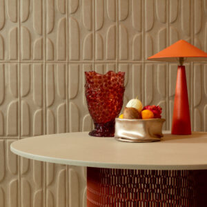 Rond tafelblad met decoratieve objecten voor een beige Elitis Forms Twisted Suedine behang met 3D-patroon.
