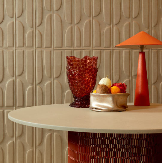 Rond tafelblad met decoratieve objecten voor een beige Elitis Forms Twisted Suedine behang met 3D-patroon.