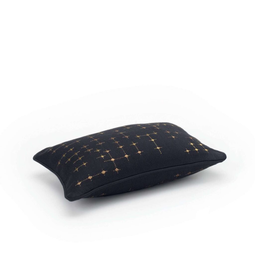 Zwart Elitis Gabriel sierkussen met goudkleurig geometrisch patroon, gezien vanaf de zijkant.