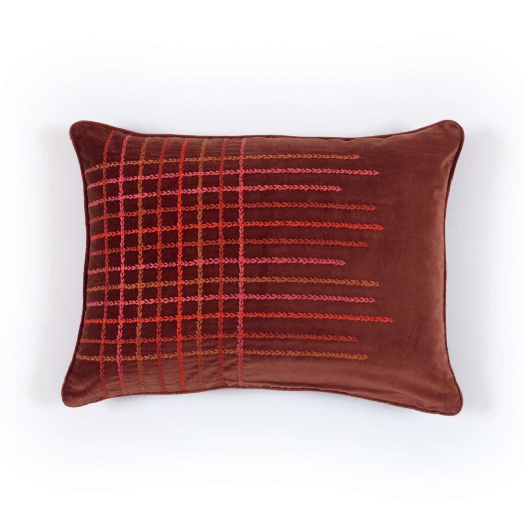 Rechthoekig Elitis Henry Co 255-72-02 kussen in warmbruin fluweel met rood en roze geborduurd ruitpatroon.