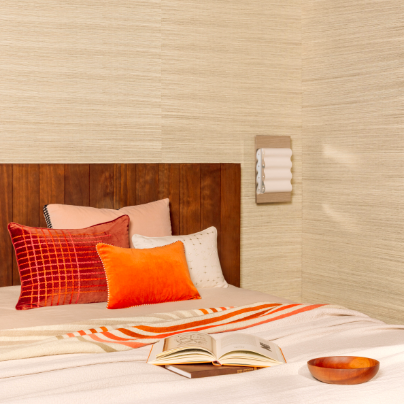 Sfeervol ingerichte slaapkamer met Elitis Henry Co 255 wandbekleding, houten hoofdbord en warme kussens op het bed.