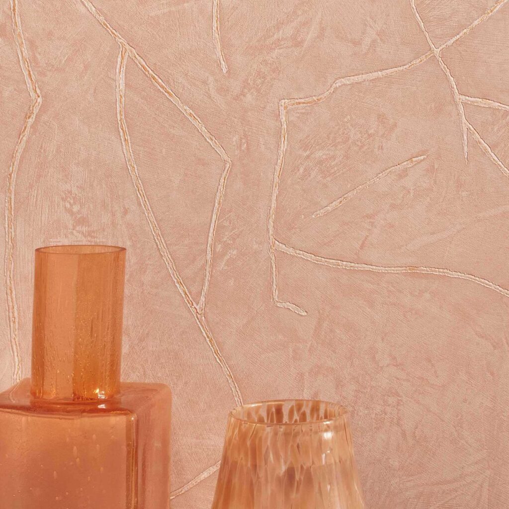 Beige Elitis Kintsugi wandbekleding met subtiel reliëf en oranjetinten decoratieve vazen op de voorgrond.