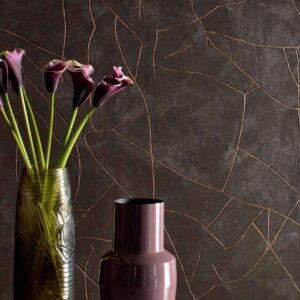 Twee designvazen met bloemen staan voor een donkere Elitis Kintsugi muur met goudkleurige scheurpatronen.