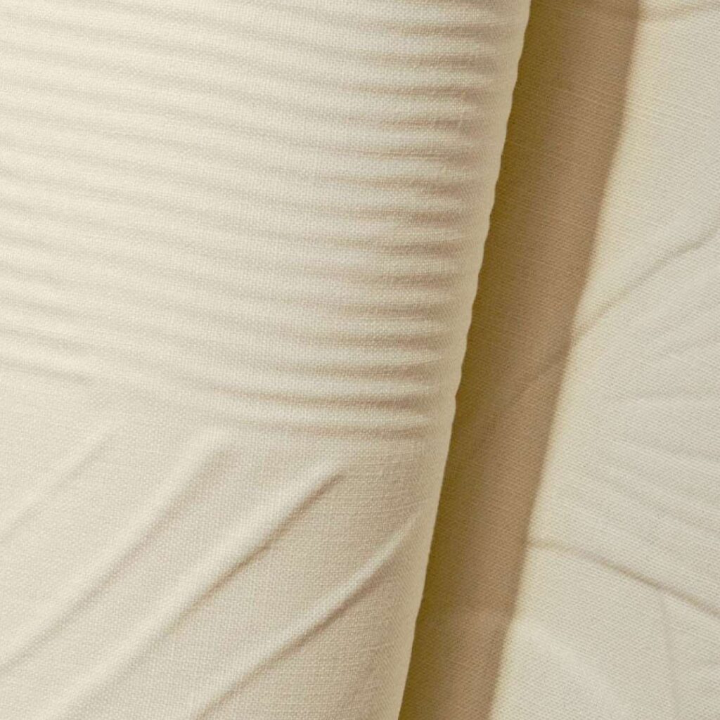 Detail van Elitis Le Jardin d’Aloès Palimpseste linnenstof met fijne ribbelstructuur in beige tint.