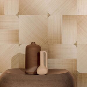 Twee aardewerken vazen staan op een ronde tafel voor een decoratieve Elitis Maestria Circe RM 1072-01 wandbekleding met geometrisch patroon in beige tinten.