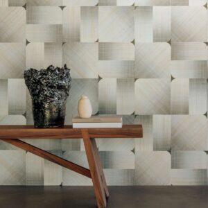 Houten tafel met decoratieve vazen tegen een Elitis Maestria Circe RM 1072 grijze designbehangmuur.