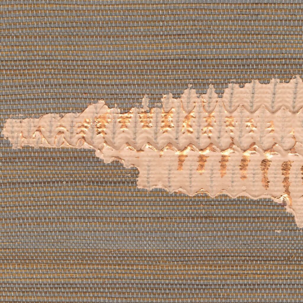 Close-up van Elitis Maestria Orion RM 1075 05 behang met een structuur van geweven textiel en een metallic koperkleurig reliëfpatroon.