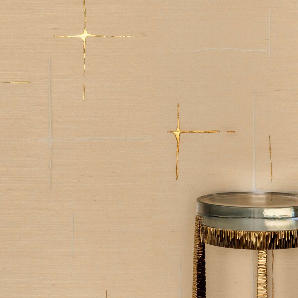 Beige Elitis Maestria Orphée RM 1076-01 behang met gouden glanselementen en een decoratieve bijzettafel op de voorgrond.