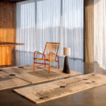 Vloerkleed en loper uit de Elitis Marcel TA 134 13 06 collectie in een modern interieur met een houten stoel en designlamp.
