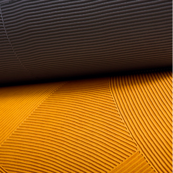 Detailopname van Elitis Circolo VP 976 wandbekleding met reliëfstructuur in grijs en okergeel.