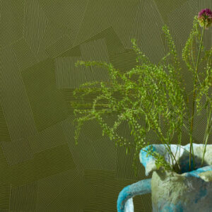 Groene Elitis Dédales VP 975 60 behang met reliëfpatroon en een vaas met dunne takjes en bloemen op de voorgrond.