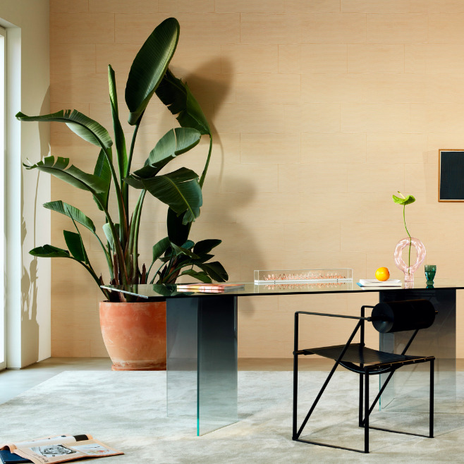 Modern interieur met een glazen bureau, designstoel, groot kamerplant en Elitis Equilibre VP 977-02 wandbekleding.