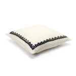 Crèmekleurig Elitis Maya kussen CO 245 88 01 met zwart en goud geborduurd randpatroon, zijaanzicht.