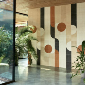 Moderne interieurhoek met Elitis Merida wandbekleding in geometrisch patroon en omringd door tropische planten.