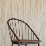 Houten stoel met gebogen rugleuning voor Elitis Silva Panorama behang met houtreliëfstructuur.
