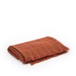 Opgevouwen Elitis plaid Edith PL 307 36 02 in bruin met roze ruitpatroon en franjes.