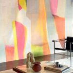 Moderne interieursetting met een Elitis Sangpi Aspirations Fusionnelles VP 1025-01 wandbekleding in vrolijke pastelkleuren en designmeubels.