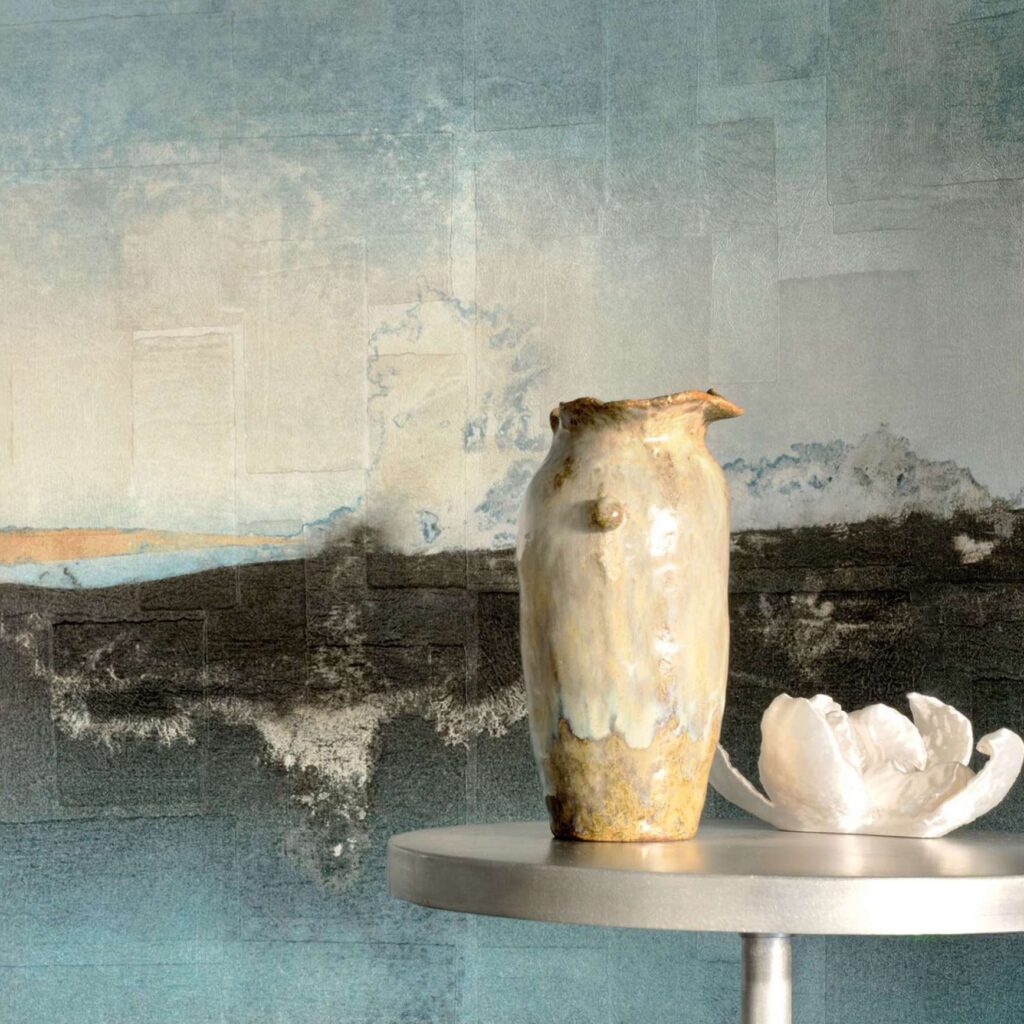 Keramische vaas en witte decoratieve bloem op een ronde tafel voor Elitis Sangpi Brumes Laquées wandbekleding.