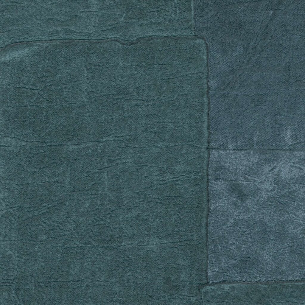 Donkerblauw Elitis Sangpi VP 1018 82 behang met een patchwork-structuur van fluwelige en leerachtige texturen.