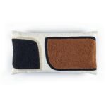 Rechthoekig Elitis sierkussen Broceliande met abstract patroon in zwart en roestbruin op een crèmekleurige achtergrond.
