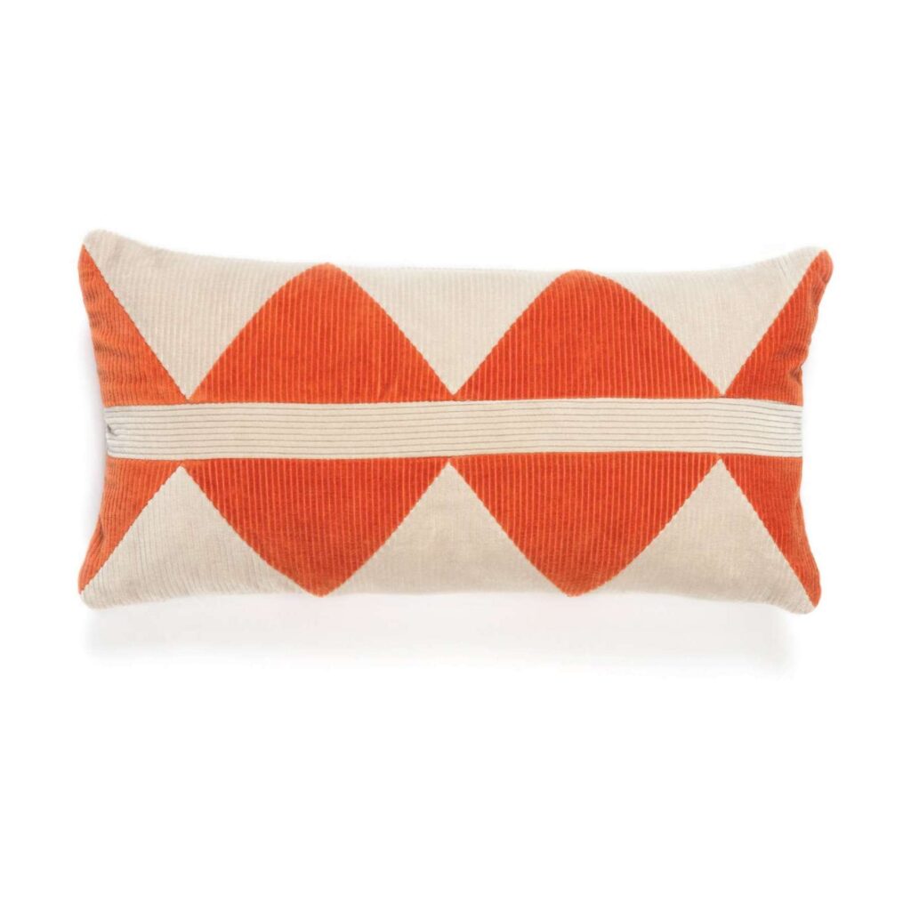 Rechthoekig Elitis-sierkussen Minos met een rood-oranje geometrisch patroon op een beige achtergrond.