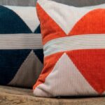 Detailopname van Elitis sierkussen Minos met een grafisch patroon in ribfluweelstof in rood, wit en donkerblauw.