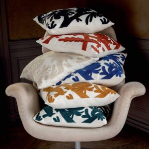 Stapel Elitis Paradise sierkussens in diverse kleuren op een beige designstoel.