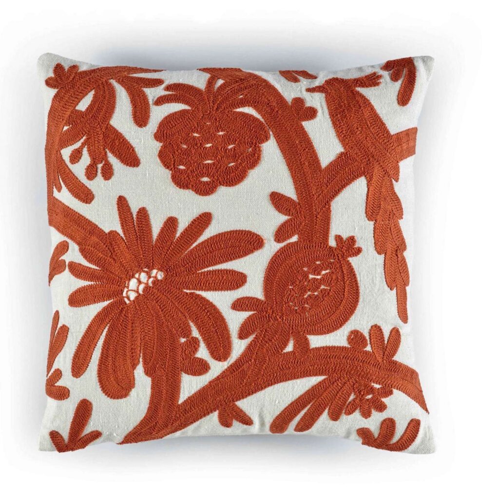 Sierkussen Elitis Paradise met rood-oranje geborduurd bloemen- en fruitpatroon op een crèmekleurige achtergrond.