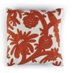 Sierkussen Elitis Paradise met rood-oranje geborduurd bloemen- en fruitpatroon op een crèmekleurige achtergrond.