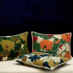 Drie Elitis-sierkussens uit de Jane-collectie met kleurrijk bloemenpatroon tegen een donkere achtergrond.