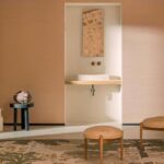 Sfeervolle interieursetting met Elitis Sisal Métallique RM 1073 wandbekleding, een wastafelnis, decoratieve spiegel en natuurlijke materialen.