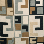 Textielpatroon van Elitis-stof LZ 871 01 Escale met geometrische vormen in beige, zwart, blauwgrijs en bruin.