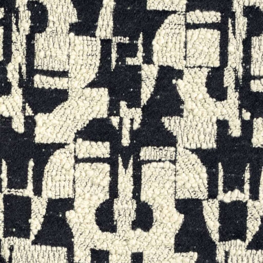 Detail van de Elitis-stof Alchimia Giorgio LR 344 01 met een zwart-wit abstract geometrisch patroon in reliëf.