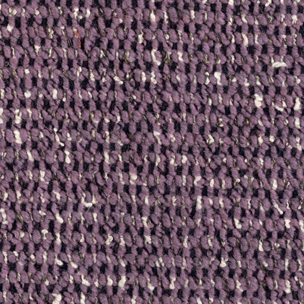 Close-up van de paarse geweven Elitis-stof Alchimia Intreccio LR 341 55 met een grove textuur.