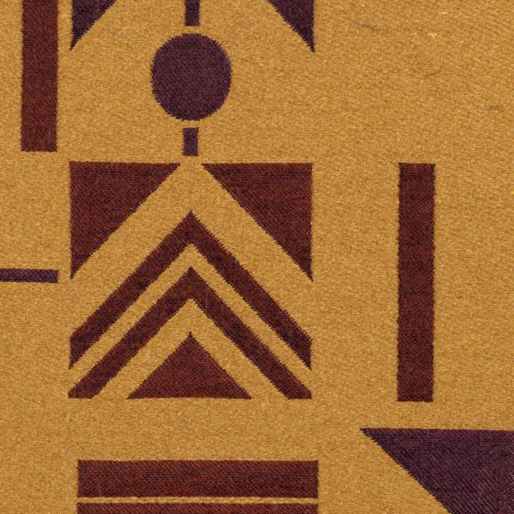 Detail van Elitis-stof Alchimia Mondo LR 342-35 met geometrisch patroon in bruin en paars op een okergele achtergrond.