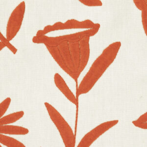 Detail van Elitis-stof Comala LZ 891 31 met een oranjerode geborduurde bloem op een licht crèmekleurige achtergrond.