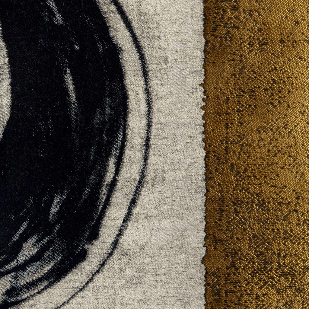 Close-up van de Elitis-stof Craft Chic Allegoria LR 339 80 met abstract zwart patroon op beige achtergrond en een goudkleurige textuurzijde.