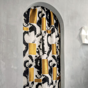 Gordijn van Elitis-stof Craft Chic Allegoria LR 339 80 met abstract patroon in zwart, wit en goud, opgehangen in een ronde deuropening.