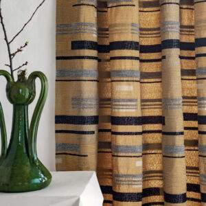 Goudbruine Elitis Craft Chic Regina LR 335 05 stof met horizontaal gestreept patroon als gordijn, naast een groene decoratieve vaas.