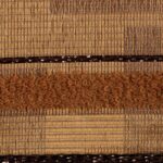 Detailopname van de Elitis-stof Craft Chic Regina LR 335 24 met een combinatie van geweven en lusvormige texturen in warme bruintinten.