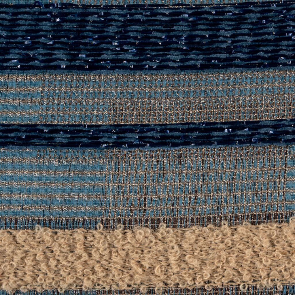 Detail van de Elitis-stof Craft Chic Regina LR 335 41 met geweven textuur in blauwe en beige tinten.