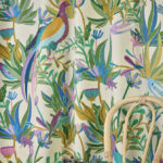 Gekleurde Elitis-stof Izamal CN 001 31 met tropisch bloemen- en vogelmotief achter een houten stoel.