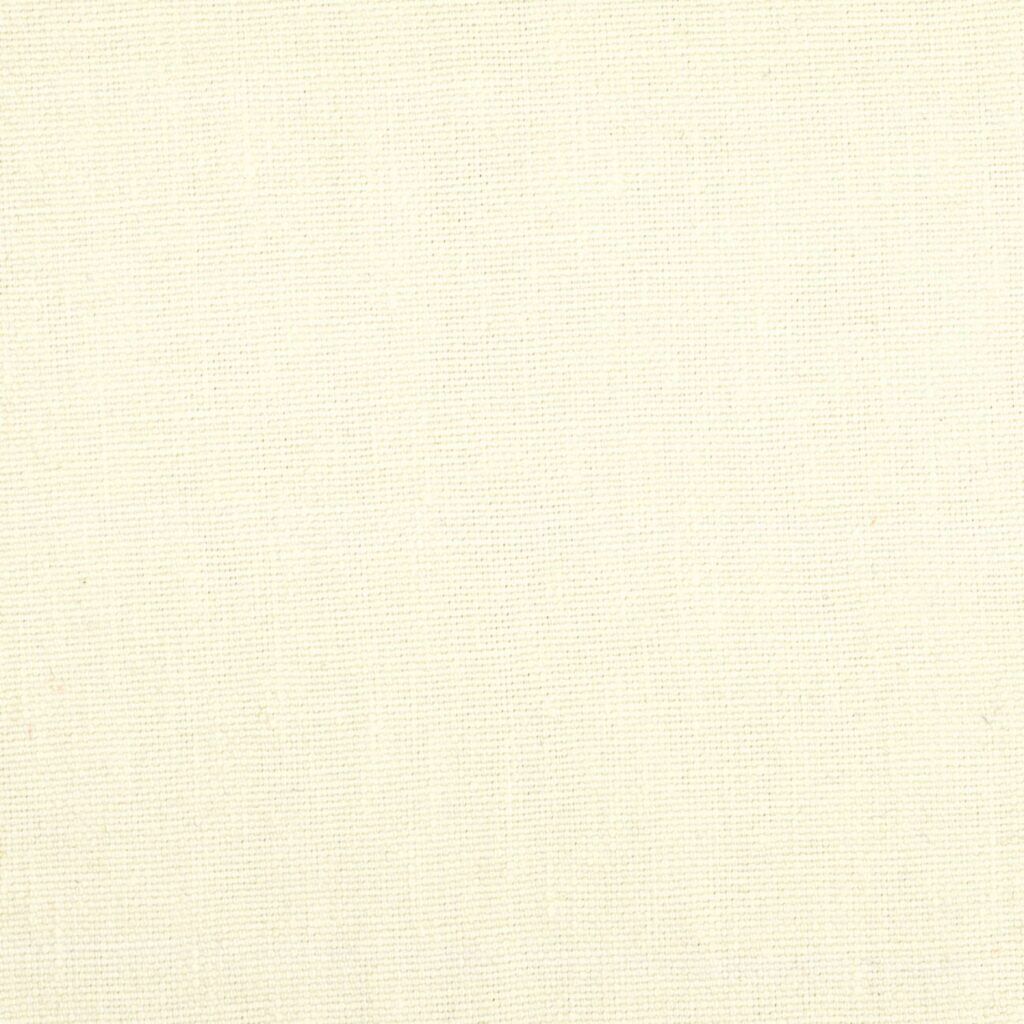 Licht beige Elitis-stof Kaila LI 890 01 met een fijne, gelijkmatige weefstructuur.