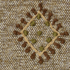 Detail van de Elitis-stof Loreto LZ 890 22 met geweven patroon en decoratieve knoopstiksels in bruin en olijfgroen.