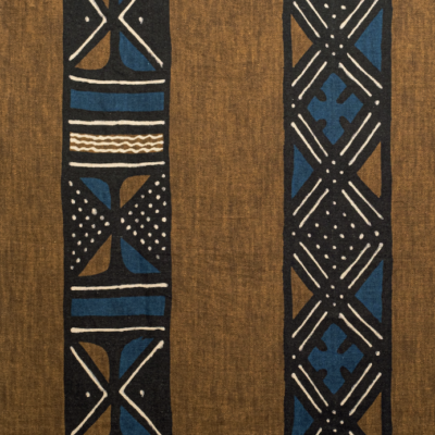 Bruin textiel uit de Elitis Escale-collectie met etnisch geïnspireerde, grafische patronen in zwart, blauw en wit.