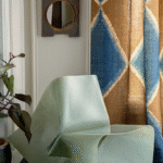 Transparante groene designstoel voor een gordijn met Elitis Escale-stof in blauw en bruin patroon.