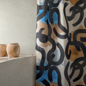Gordijn van Elitis-stof uit de Escale-collectie met abstract zwart penseelpatroon en blauwe en bruine accenten, naast twee aardewerken potten.